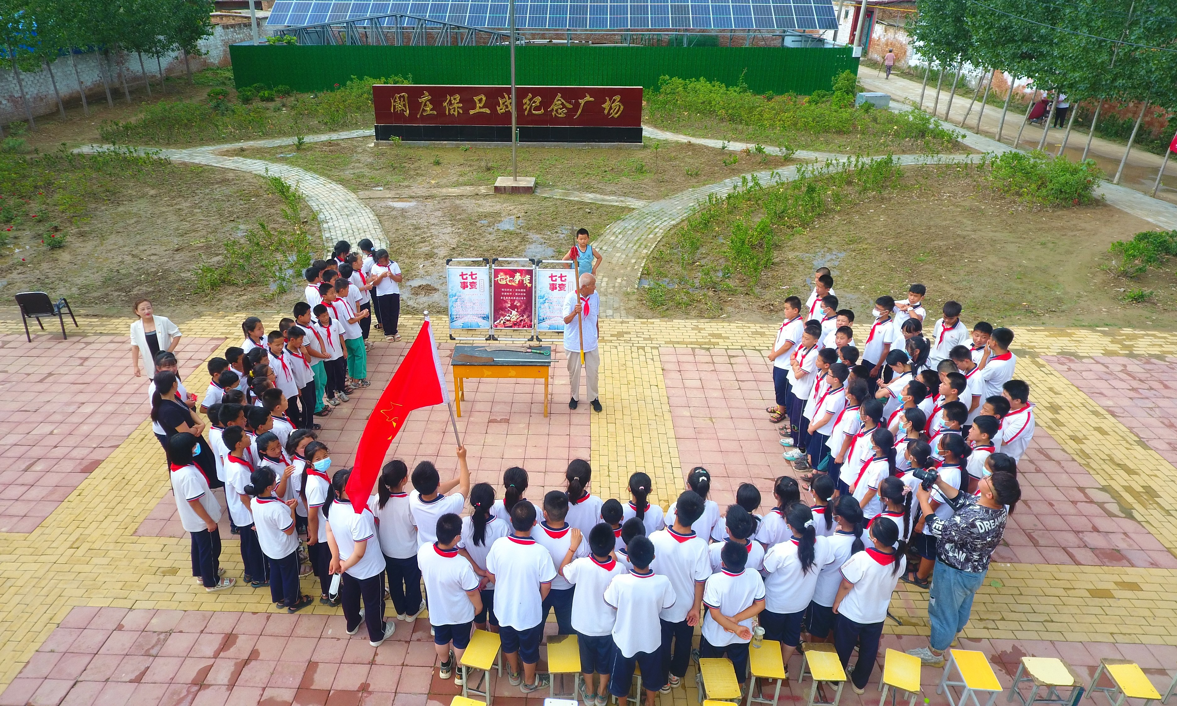 2022年7月6日，山東省聊城市，在茌平區(qū)菜屯鎮(zhèn)闞莊村的闞莊保衛(wèi)戰(zhàn)紀(jì)念廣場(chǎng)，闞莊保衛(wèi)戰(zhàn)親歷者王光木老人，為小學(xué)生們講述抗戰(zhàn)故事，展示大刀、長(zhǎng)矛。