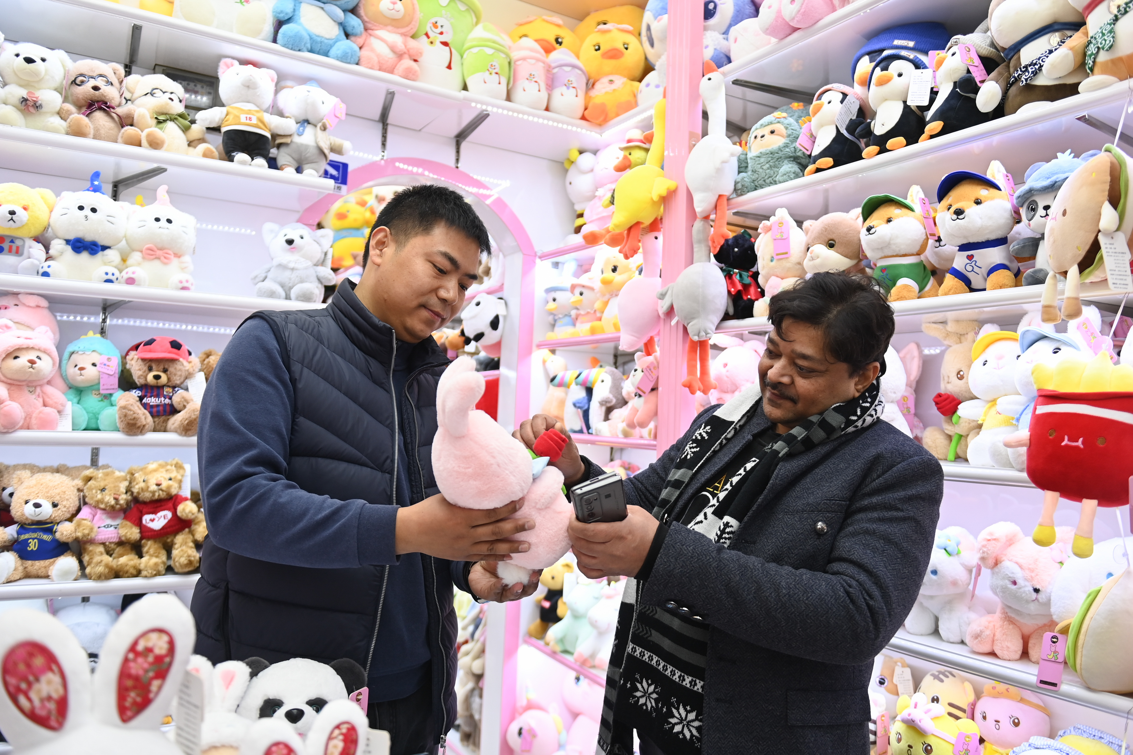 2023年2月2日，來(lái)自印度的客商（右）在義烏國(guó)際商貿(mào)城的一家玩具店鋪內(nèi)選購(gòu)。